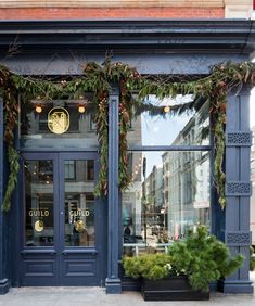 a store front decorated with greenery and lights