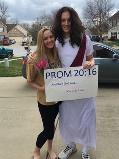 two women standing next to each other holding a sign