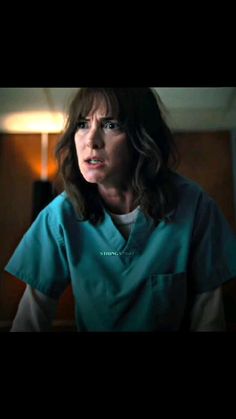 a woman in scrubs is looking at the camera