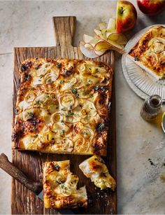 some food is laying out on a cutting board next to an apple and cheese dish