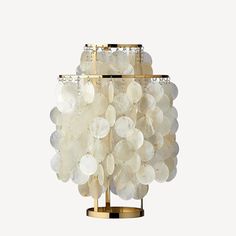 a table lamp made out of shells on a metal stand