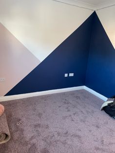 an empty room with blue and white painted on the walls, carpeted flooring