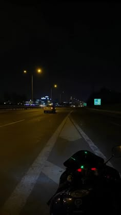 the motorcycle is driving down the road at night