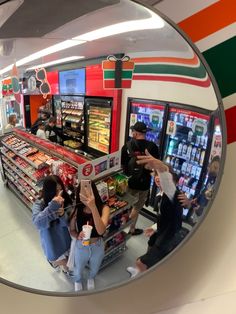 a group of people standing in front of a vending machine at a grocery store