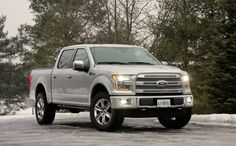 a silver truck is parked in the snow