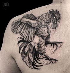 a black and white bird tattoo on the back of a man's upper arm