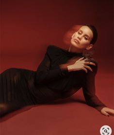 a woman is laying on the floor with her legs spread out and holding a bird