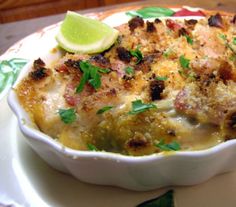 a casserole dish on a plate with a lime wedge