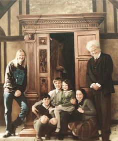 a group of people standing next to each other in front of a wooden cabinet and door