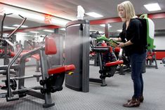 a woman standing next to a gym machine