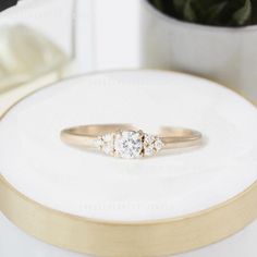 a diamond ring sitting on top of a white surface next to a potted plant