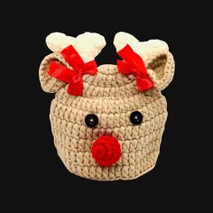 a small crocheted basket with a red nose and bow on the top that has been made to look like a reindeer's head