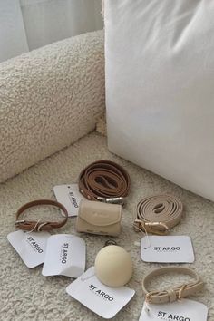 the contents of a purse are laid out on the floor next to some tags and cords