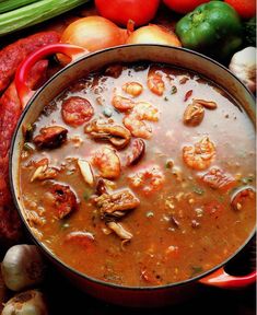 a pot filled with soup surrounded by vegetables