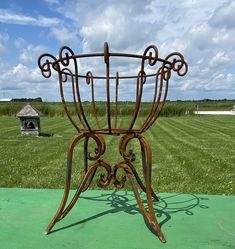 a metal plant stand sitting on top of a green field