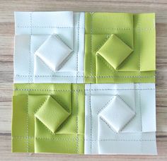 four squares with white and green stitching on them