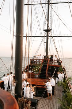 several people are standing on the deck of a boat