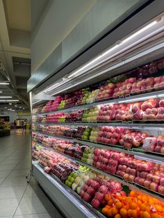 an aisle in a grocery store filled with fruits and vegetables