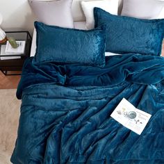 a blue comforter and pillows on a bed