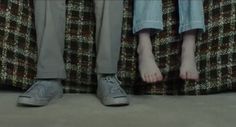 two people standing next to each other with their feet on the ground in front of them