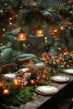 a table with candles, plates and greenery is set up for an outdoor dinner