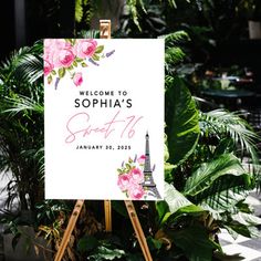 a welcome sign with pink flowers and the eiffel tower in the background