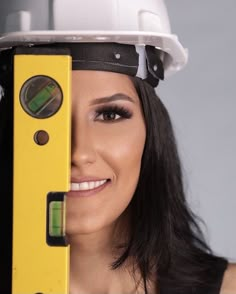 a woman wearing a hard hat and holding a level