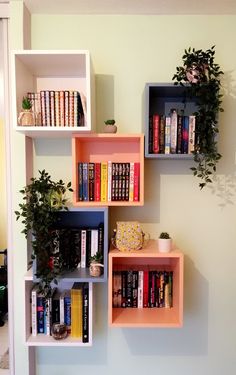 the bookshelves are filled with many different types of books and plant pots on them