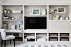 a living room filled with furniture and a flat screen tv on top of a wooden shelf