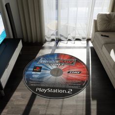 a video game disc sitting on the floor in front of a tv