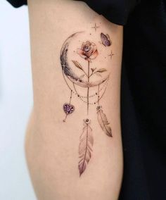 a woman with a tattoo on her stomach has a rose and a dream catcher in it