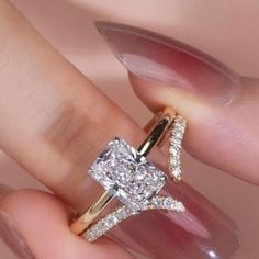 a woman's hand holding a diamond ring with two diamonds on the top and bottom