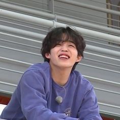 a boy sitting on the bleachers laughing