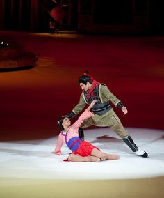 two people are performing on an ice rink