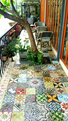 an outdoor patio with colorful tiles on the floor and potted plants in the corner