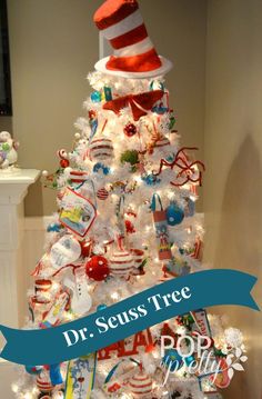 a white christmas tree decorated with dr seuss's hats and candy canes