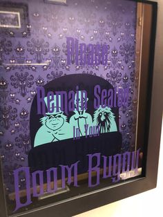 a purple and black sign in a glass case