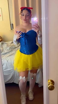 a woman in a blue and yellow dress taking a selfie