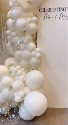 white balloons are arranged in the shape of a column