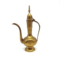 an old brass teapot with a handle on the side and a cup in the middle