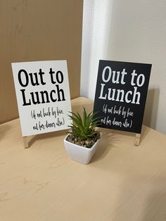 two signs that say out to lunch and out to lunch are sitting on a table