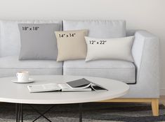 a coffee table with two pillows and a book on it in front of a couch