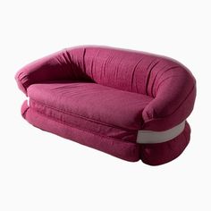 a pink couch sitting on top of a white floor