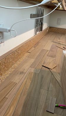 an unfinished room with wood flooring and electrical wires attached to the wall above it