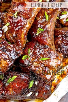 chinese sticky ribs with sauce and green onions in the middle, on a white plate