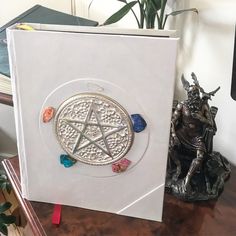 a book with a pentagramter on it sitting next to a statue