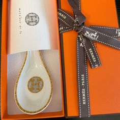 an orange box with a white spoon in it and a ribbon around the handle that is attached