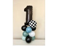 balloons are stacked on top of each other in front of a number one balloon