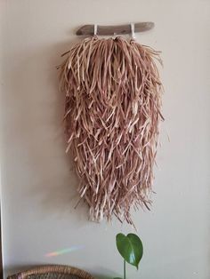 a wall hanging made out of straw with a surfboard on the top of it