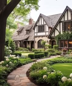 a large house with many windows and lots of greenery in the front yard area